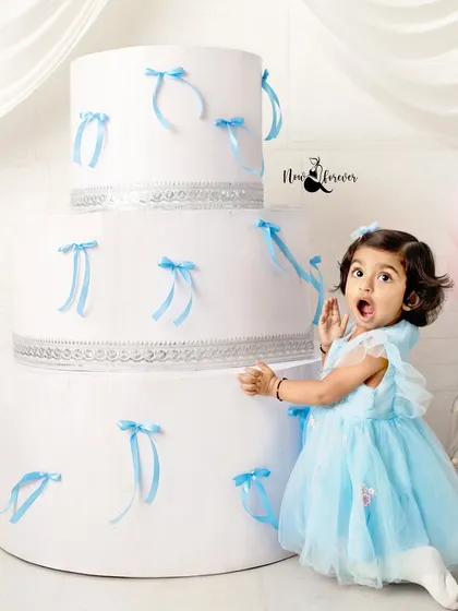 A gasp of surprise from the birthday girl! Turning two is a big deal, and her expression next to the giant cake prop is absolutely priceless.
