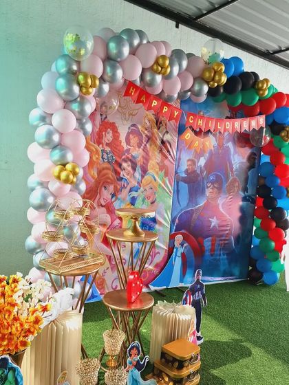 This image highlights the balloon arch detail, combining different colors and sizes to match the dual-theme design for the corporate Children's Day party.