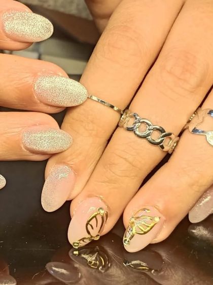 A closer look at the 3D gold butterfly art, paired with sparkling cat-eye nails.