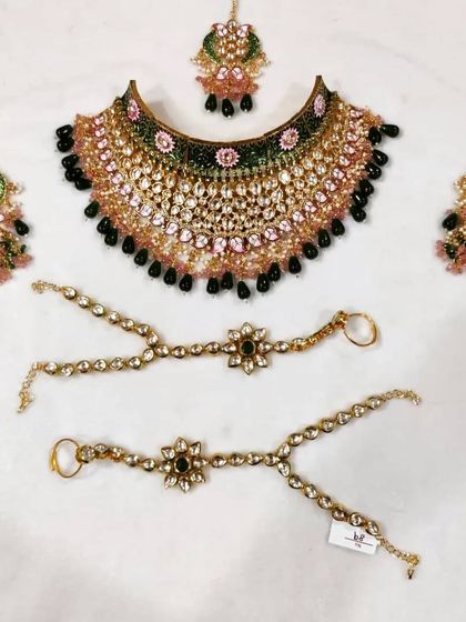 The complete rental set chosen by the bride. It includes the choker, matching earrings, and hathphool, all featuring a unique black bead and pink stone design.