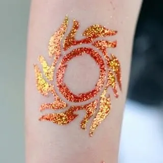 This fiery sun tattoo in orange and gold glitter is perfect for festivals and celebrations like Diwali. It adds a warm, vibrant touch to any party look.