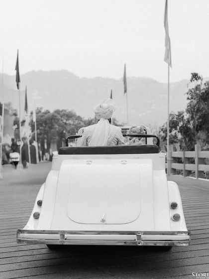 The groom's classic departure in a vintage car, a timeless black and white frame from a wedding in the hills of Mussoorie.