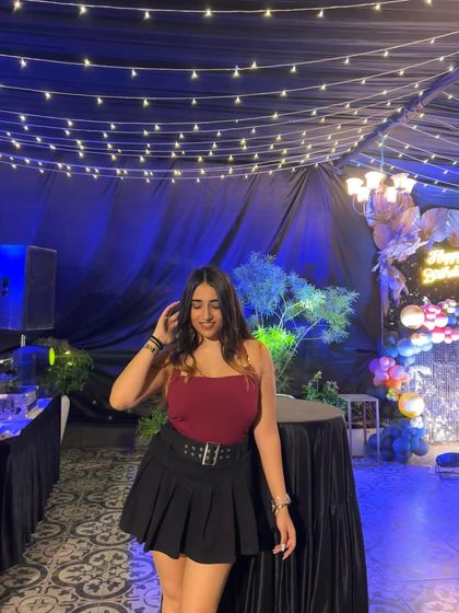 A final pose in the cherry-colored party look. This is a great example of a fun and stylish outfit for a celebration.