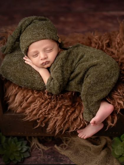Cozy and calm in a rustic green outfit. The deep colors and textures in this newborn portrait create a warm and earthy feel.