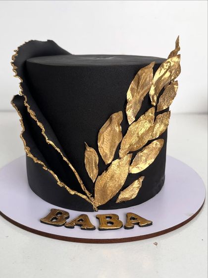 Another view of the bold black and gold cake, showcasing the sharp edges and the beautiful contrast between the matte black and shimmering gold.