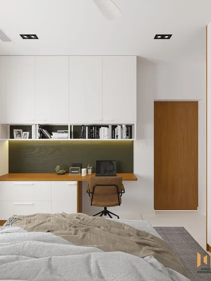 The study and storage unit in this compact bedroom, featuring white overhead cabinets and a wooden desk to maximize space without feeling cluttered.