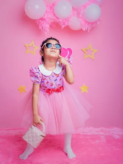This little doll is serving looks. With sunglasses and a purse, our Barbie-themed shoot lets your child express their inner fashionista.