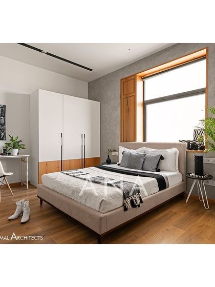 This guest bedroom in Apartment 704 includes a study area, making it a functional and versatile space. The design uses a minimal color palette with wooden flooring and furniture for warmth.