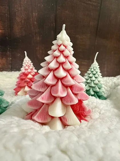 A beautiful red and white ombre Christmas tree candle, adding a cute and festive touch to your home.