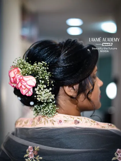 A classic bridal bun adorned with fresh flowers. We teach students how to properly incorporate flowers and other accessories into their hairstyles for a romantic finish.