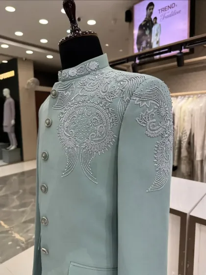 A beautiful pastel green Jodhpuri suit with delicate, tone-on-tone white embroidery and beadwork on the chest and shoulder. This is an elegant choice for a daytime wedding or event.