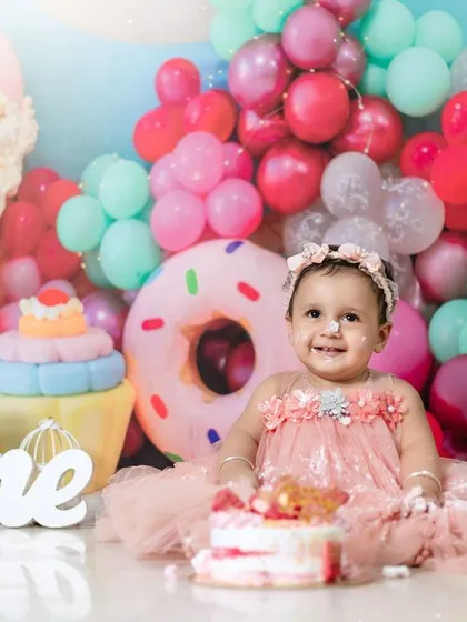 A sweet and messy cake smash in our candy-themed studio. Her happy, frosting-covered smile says it all.
