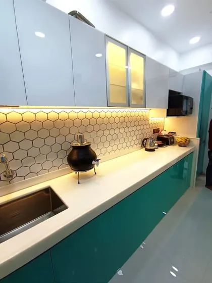 This perspective highlights the long, uninterrupted white countertop, providing ample workspace. The glass-fronted upper cabinets add a sense of lightness to the design.
