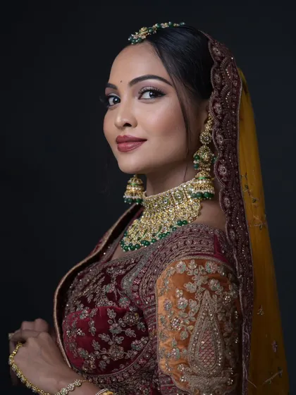 A classic bridal portrait with a multi-toned lehenga. The makeup is kept warm and neutral to balance the colorful outfit.