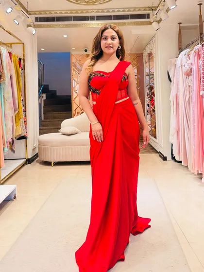 This stunning red corset saree is a perfect example of modern Indian wear. The corset blouse cinches the waist and adds glamour, while the pre-draped crepe fabric is fuss-free and creates a beautiful, elongated silhouette.