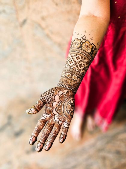 A single arm shot of a lovely bridal design, with a focus on the paisley and floral motifs.