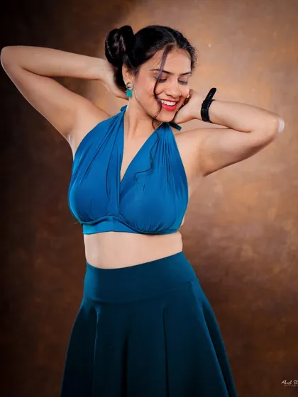 A joyful and carefree studio portrait. The model's smile and relaxed pose create a very approachable and happy image.