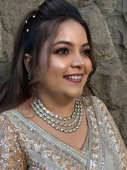 A beautiful candid shot of a reception bride. Her makeup features a soft smokey eye and a nude lip, paired with a stunning diamond necklace.