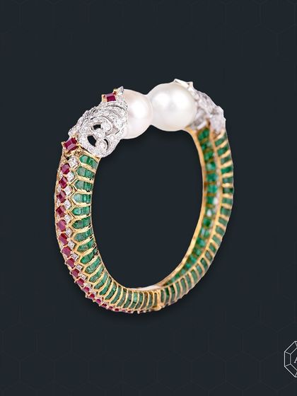 This Ruby, Emerald, and Diamond Bangle brings a touch of timeless luxury to your every moment.
