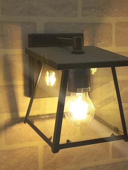 A classic outdoor lantern with a vintage-style bulb, showcasing the trend of blending traditional design with modern LED technology.