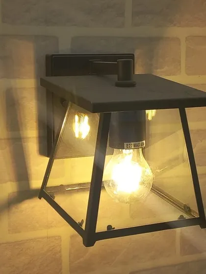A classic outdoor lantern with a vintage-style bulb, showcasing the trend of blending traditional design with modern LED technology.