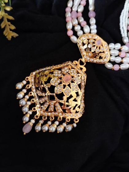 A closer look at the pendant of the 'गुलाबी' (Gulabi) necklace. The light pink stones and intricate Jadau work make it a unique and beautiful piece.