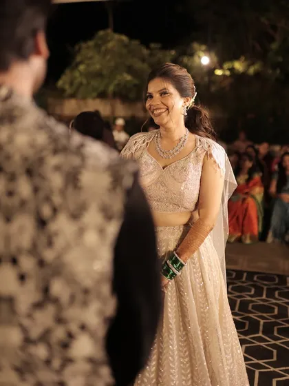 A candid moment of the bride smiling at her groom during their sangeet.