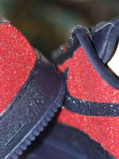 A close-up of the ombre glitter effect on the black and red AF1s. Applying the glitter evenly to create a smooth transition is a meticulous but rewarding process.