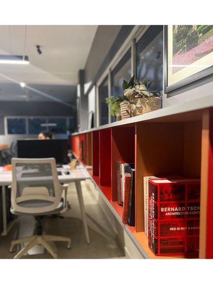 Our Pune studio, located in the leafy neighborhood of Koregaon Park. The workspace is organized around a long shelving unit in red, yellow, and blue, which houses our library of architectural books and models, reflecting our vibrant and intellectual design approach.