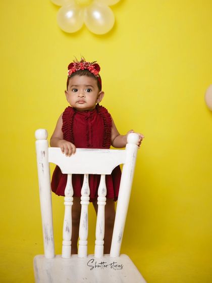 A simple and bold setup with a red outfit against a bright yellow background, perfect for a minimalist cake smash.