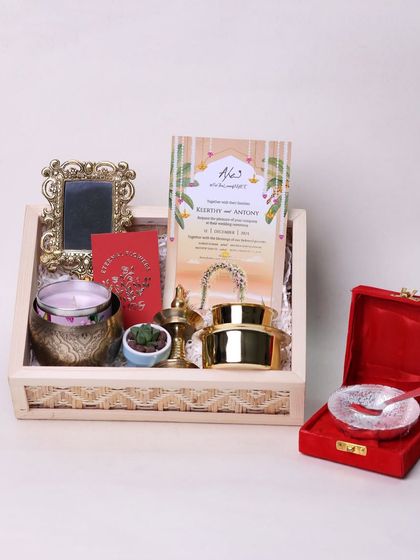 This exquisite wedding invitation hamper was crafted for a celebrity wedding. It includes a custom invitation card, a scented candle, a brass lamp, and a silver bowl set in a red velvet box.