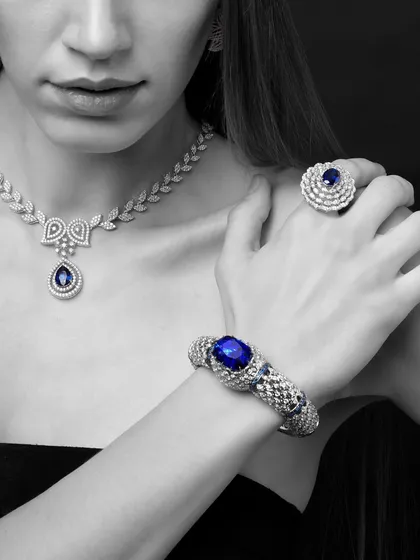 A classic and elegant pose highlighting a sapphire and diamond set from Yoube Jewellery. The selective color on the deep blue sapphires makes them look incredibly rich and luxurious against the monochrome palette.