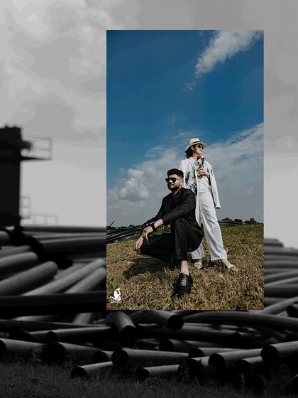 A powerful pose from a modern pre-wedding shoot, with the couple framed against a dramatic sky and industrial elements.