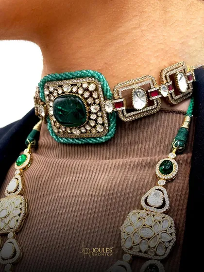 A side view of the layered emerald set, focusing on the unique thread-wrapped choker and its geometric design elements.