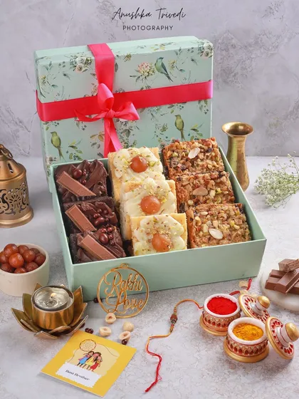 A complete Rakhi gift hamper, styled with a rakhi, kumkum, and other traditional elements. The photo tells a complete story of the festival.