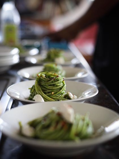 A line-up of perfectly plated pesto spaghetti, ready to be served to our happy cooks.