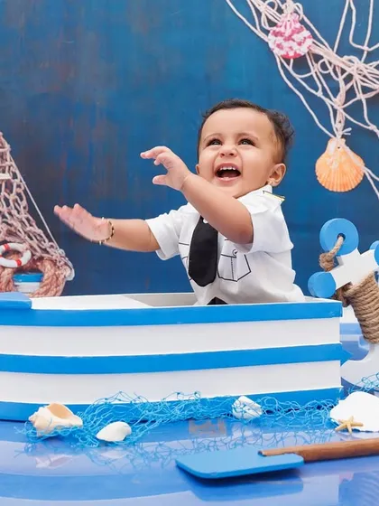 A moment of pure joy as this little sailor laughs and plays in his boat during his first birthday session.