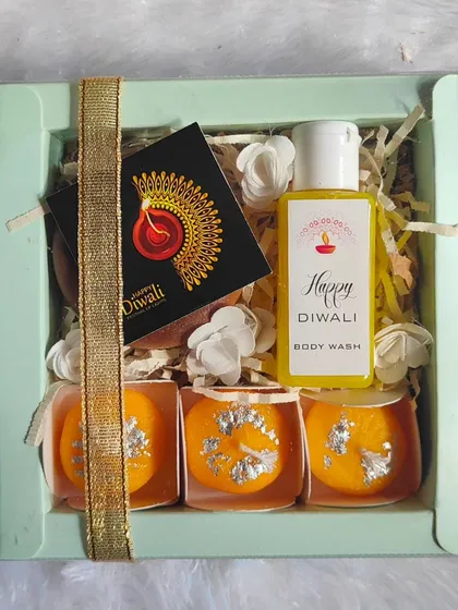 This Diwali gift box comes with three ladoo-shaped candles and a bottle of "Happy Diwali" body wash, tied with a golden ribbon.