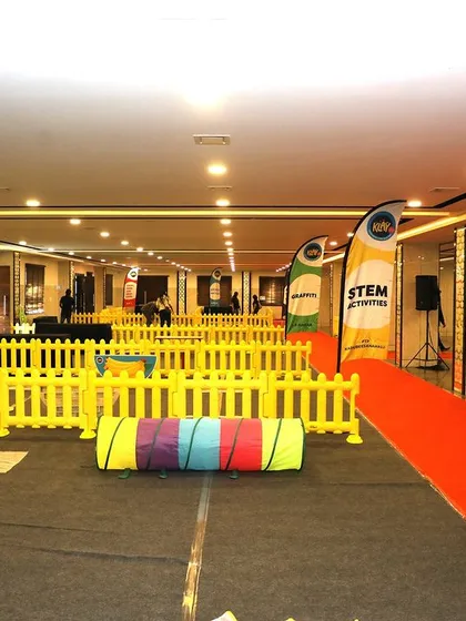 I design engaging, large-scale indoor carnivals like this "Get Set Go" event for Klay. This setup features a sensory obstacle walk with tunnels and hoops, all laid out with a red carpet and safety barriers to manage the flow of over 650 families.