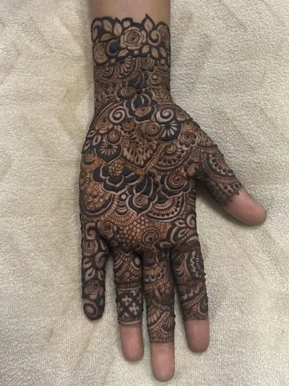 This intricate palm design is packed with detail, including mandalas, swirls, and floral elements. It's a full-coverage look perfect for a big celebration.