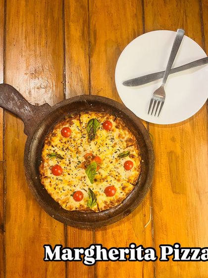 A closer look at our delicious Margherita pizza, served on a rustic wooden board.