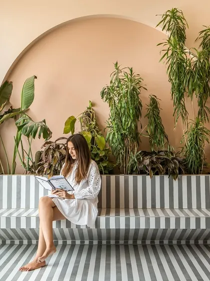 The semi-open terrace features a striking striped floor made from water-jet cut tiles, which extends into a built-in bench. It's a perfect spot for quiet moments surrounded by greenery.