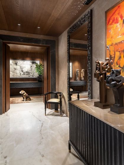 Another view of the Camellias lobby, where a fluted sideboard and a sculptural mirror are juxtaposed with bold modern art. Even the family pet finds a quiet corner in this art-filled space.