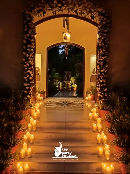 I believe in creating breathtaking entrances. For this intimate wedding, I lined the steps and walkway with hundreds of candles and framed the doorway with a lush arch of white carnations, creating a warm, romantic, and truly magical welcome for the guests.