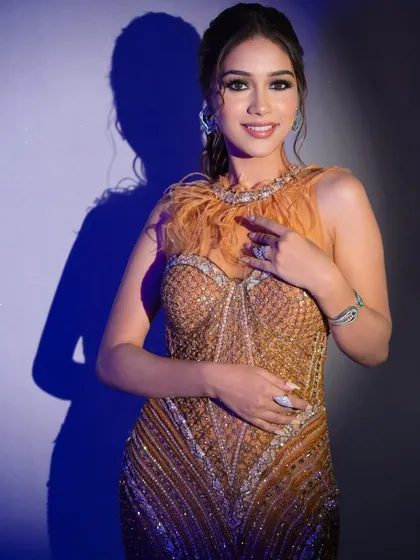 This full-length shot showcases a high-fashion gown, complemented by bold and beautiful makeup.
