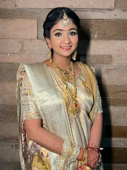 A close-up of this glowing mom-to-be, her South Indian inspired look is completed with traditional gold jewelry and a radiant smile.