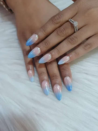 A beautiful and clean look featuring a seamless ombre blend from a natural nude base to a soft sky blue. These almond-shaped gel extensions are perfect for an elegant, everyday style with a pop of color.
