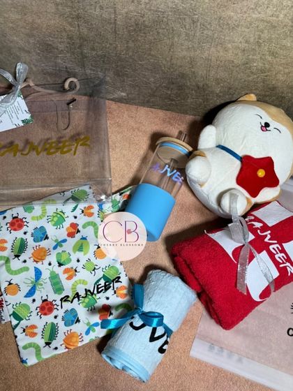A special personalised gift we curated for a birthday boy. It includes a custom tote bag, sipper, and towels, all featuring his name, along with a cute plush toy.