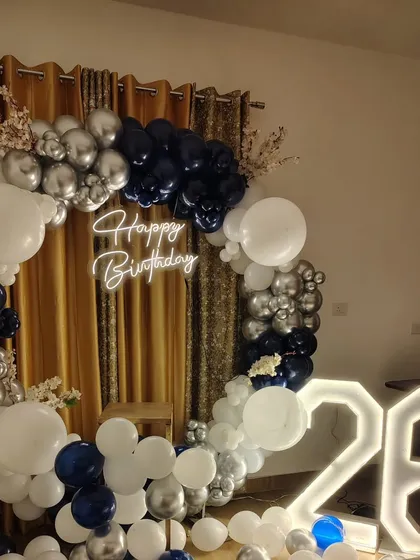 I also do modern and elegant setups for adult birthdays. This 26th birthday features a stylish navy blue, silver, and white balloon ring, a custom neon sign, and large illuminated marquee numbers.