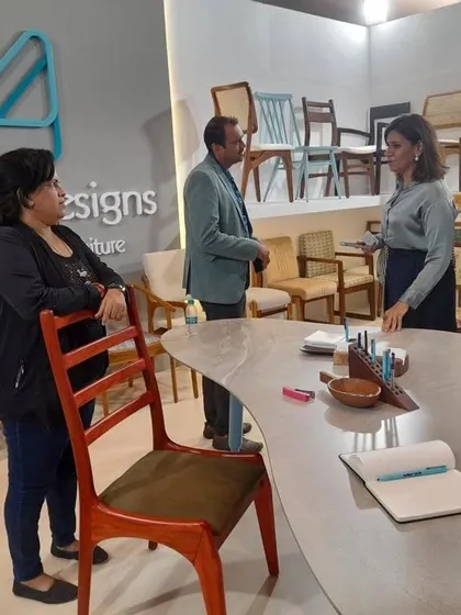 Explaining the different wood finishes and customization options available for my chairs to visitors at the iDAC Mumbai event.